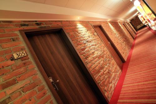 a brick wall next to a wooden door at Browar CzenstochoviA Hotel&Spa in Częstochowa