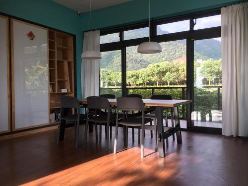 a dining room with a table and chairs and a large window at Sun Moon Mountain Farm Homestay in Yuanshan