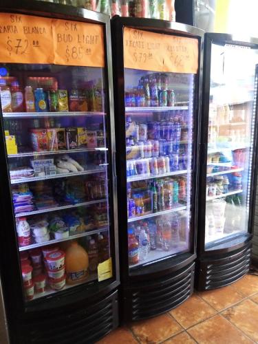two refrigerators with food and drinks in them at POSAD FAMILIAR EL PARAiSO in Xilitla
