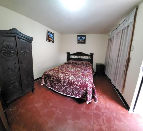 a bedroom with a bed with a red bedspread at Hospedaje El Viajero Antigua llI in Antigua Guatemala