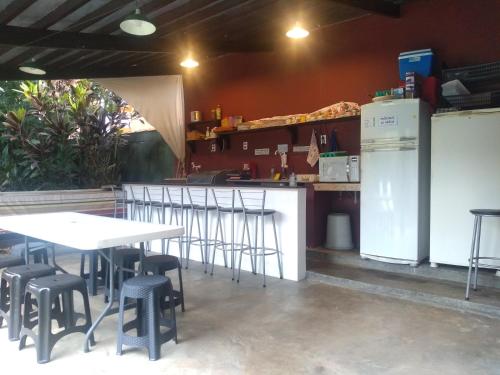 a kitchen with tables and stools in a restaurant at Trip Maresias Suítes in Maresias