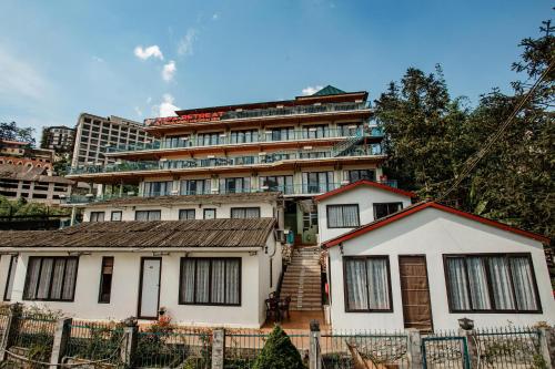 a white house with a building in the background at SaPa Retreat Condotel in Sa Pa