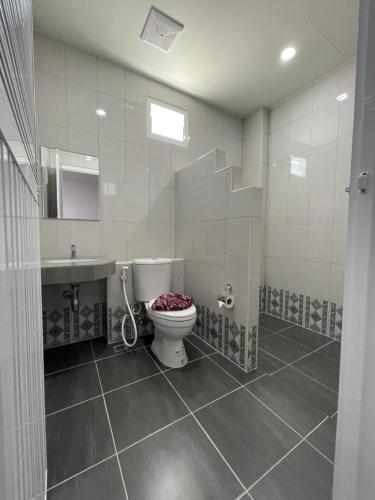 a bathroom with a toilet and a sink at บ้านบัว เมืองใหม่ Baanbua Muangmai in Thalang