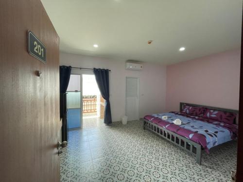 a bedroom with a bed in the corner of a room at บ้านบัว เมืองใหม่ Baanbua Muangmai in Thalang