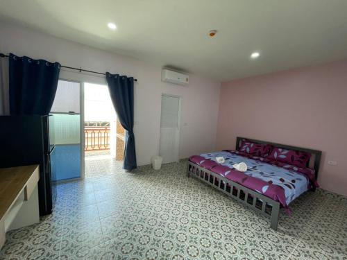 a bedroom with a bed and a television in it at บ้านบัว เมืองใหม่ Baanbua Muangmai in Thalang