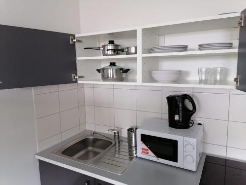 a kitchen with a sink and a microwave at Panorama Hostel in Frankfurt