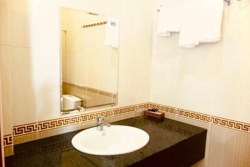 a bathroom with a sink and a mirror at Thien Phu Nghia 2 - Hotel Phu Quoc in Phú Quốc