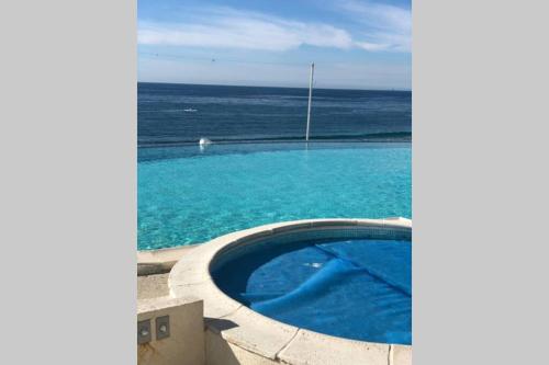 a swimming pool with the ocean in the background at Beachfront Condo close Puerto Nuevo, Papas, and Valle de Guadalupe in Rosarito