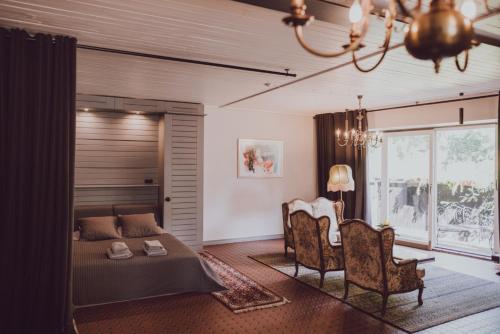 a bedroom with a bed and a table and chairs at &Scaron;aha Kluba Apartamenti in Kuldīga