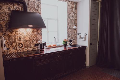 a kitchen with a counter with a sink and a window at &Scaron;aha Kluba Apartamenti in Kuldīga