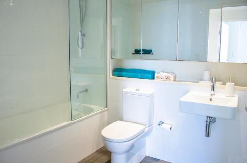 y baño con aseo, lavabo y ducha. en Absolute Waterfront - Tropical Sunrise Apartment Over The Water en Darwin