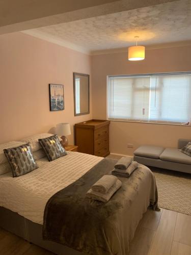 a bedroom with a bed and a window and a couch at Eastbourne Town centre Maisonette apartment in Eastbourne