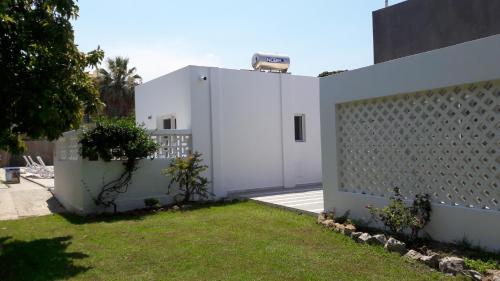 a white building with a fence and a yard at Villa Elpiniki in Ixia