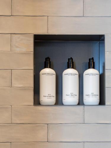 four bottles of soap sitting on a shelf at Poorter Boutique Hotel Brielle in Brielle