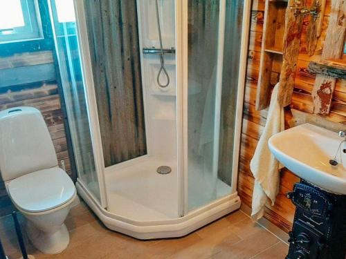 a bathroom with a shower and a toilet and a sink at 11 person holiday home in Syvde in Myklebost