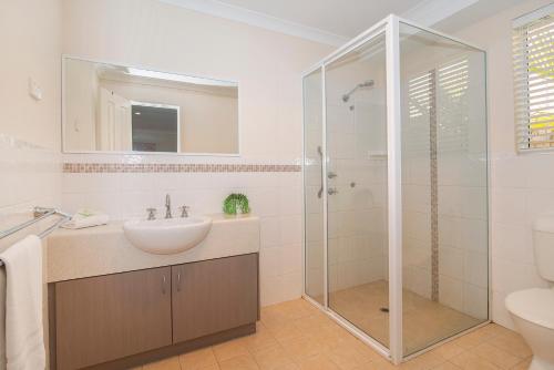 a white bathroom with a sink and a shower at Central Townhouse Margaret River in Margaret River Town