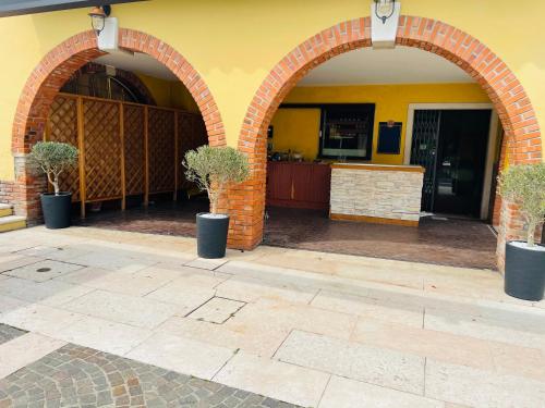 two arched entrances to a building with two potted trees at Appartamento Azzurro in Verona