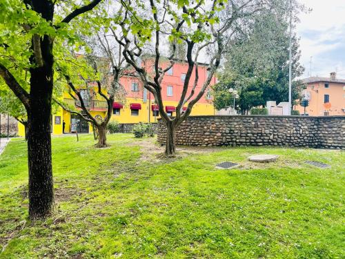 a group of trees in a park next to a wall at Appartamento Azzurro in Verona
