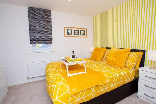 a bedroom with a yellow bed with a tray on it at Mills Apartment - Two bedroom en-suite apartment in Northampton