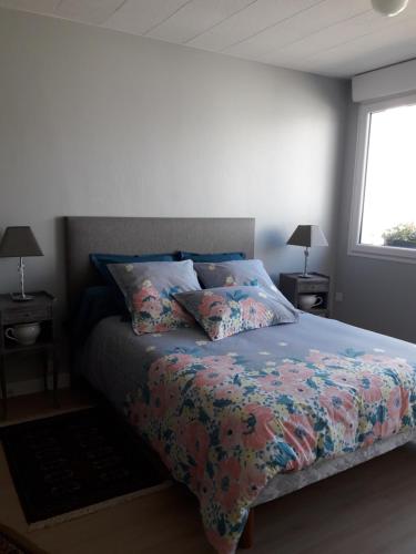 - une chambre avec un lit doté d'une couverture colorée et d'une fenêtre dans l'établissement Gite 2 personnes, à Plonévez-Porzay