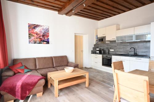 a living room with a couch and a table at Waldschlössl Schneedörfl in Reichenau