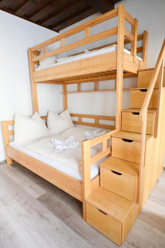 a wooden bunk bed with a ladder in a room at Waldschlössl Schneedörfl in Reichenau