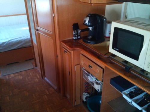 une cuisine avec un four micro-ondes et un ordinateur sur une table dans l'établissement Caravane camping Prée Marennes, à Marennes