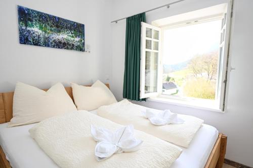 a white bed with bows on it in a room with a window at Waldschlössl Schneedörfl in Reichenau