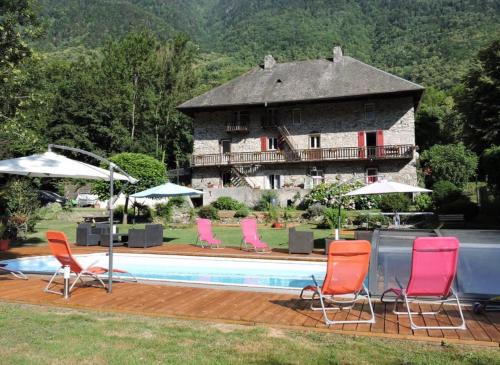 a group of chairs and a swimming pool with a building at La Perle de la Lauzière, chambres d hôtes in Argentine