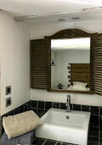 a bathroom with a sink and a mirror at La Perle de la Lauzière, chambres d hôtes in Argentine
