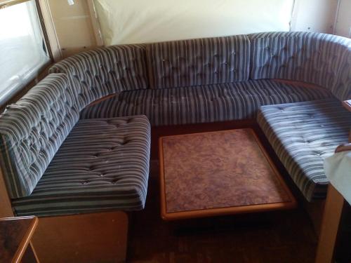 un salon avec un canapé et une table dans l'établissement Caravane camping Prée Marennes, à Marennes