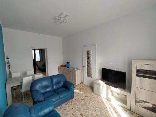 uma sala de estar com um sofá azul e uma televisão em Appartamento vacanze Piazza del Popolo em Marsala