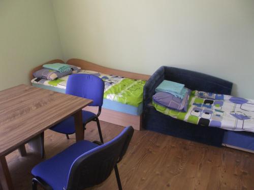 a room with two beds and a table and chairs at Nakvynė Rokiškyje in Rokiškis