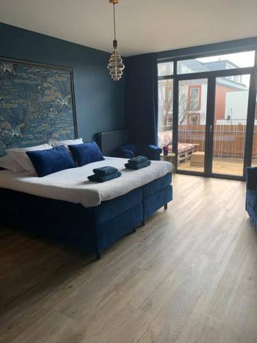 a bedroom with a large bed with blue walls at The Rock in Zandvoort