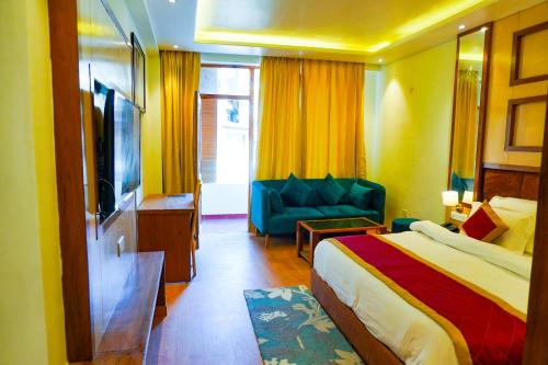 a hotel room with a bed and a couch at Comfort Inn Snow Park - Manali in Manāli