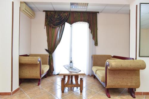 a living room with two chairs and a couch and a window at Hotel Grbalj in Budva