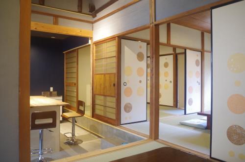 Cette chambre dispose de portes vitrées, d'une table et de chaises. dans l'établissement Bed&Bicycle, à Kashihara
