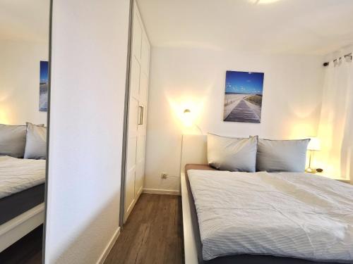 1 dormitorio con cama y espejo en Strandkorb, en Horumersiel
