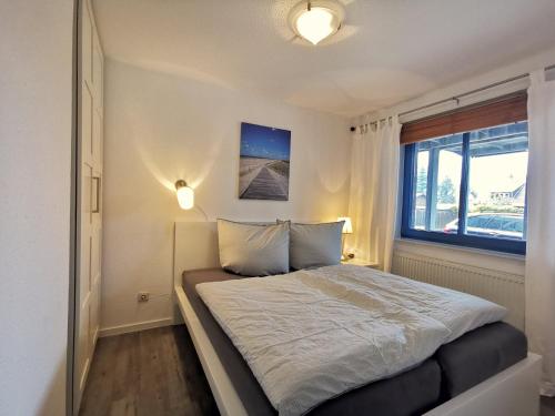 a bedroom with a large bed and a window at Strandkorb in Horumersiel