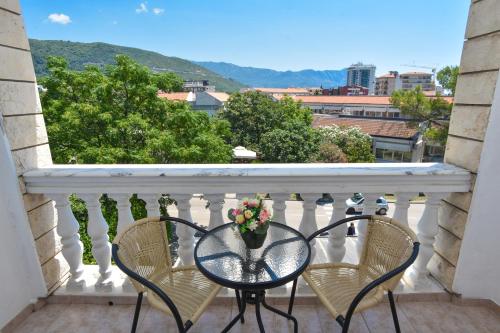 a balcony with two chairs and a table with flowers on it at Hotel Grbalj in Budva