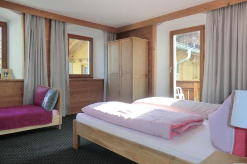 a bedroom with a bed and a chair at Ferienwohnungen Hell in Uderns