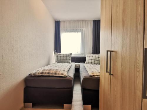ホールマージールにあるSandbankのベッド2台と窓が備わる小さな客室です。