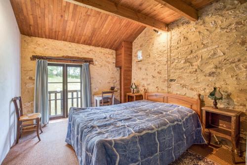 een slaapkamer met een bed in een kamer met een stenen muur bij Maison de 4 chambres avec terrasse amenagee et wifi a Gavaudun in Gavaudun