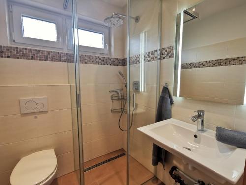 une salle de bain avec toilettes, lavabo et douche dans l'établissement Sandstrand, à Wangerland