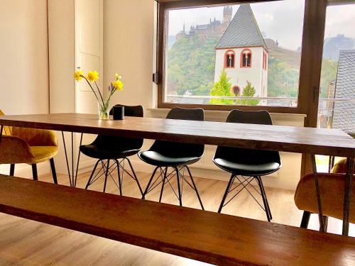 a dining room table with chairs and a large window at Haus Mosel Tales in Cochem für bis zu 9 Personen in Cochem