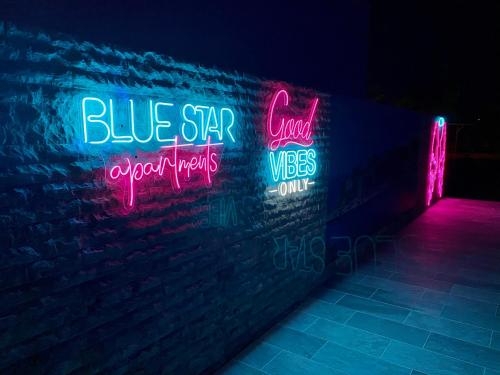 a brick wall with neon signs on it at Blue Star Apartments in Ulcinj