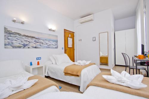 バルセロナにあるバルセロナ シティ ホテルのベッド2台とダイニングルームが備わるホテルルームです。