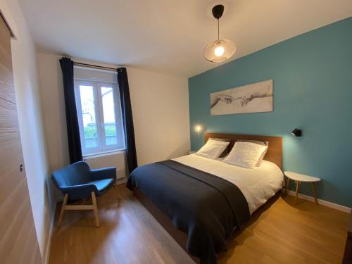 ein Schlafzimmer mit einem Bett, einem Stuhl und einem Fenster in der Unterkunft Le 44 - T2 rénové moderne et confortable en centre-ville in Montluçon