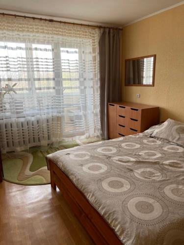 a bedroom with a large bed and a window at Здається квартира подобово in Kamianets-Podilskyi