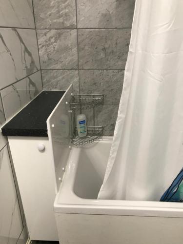 a bathroom with a bath tub with a shower curtain at Ladysmith House in Plymouth
